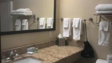 A bathroom with a sink, mirror, towel rack, and toilet.