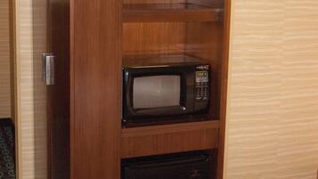 Een houten kast met een magnetron en een minibar.