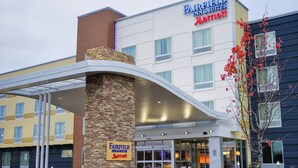 A Fairfield Inn & Suites by Marriott hotel with a modern entrance and a stone pillar. - Fairfield Inn & Suites Canton South (Canton)