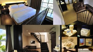 Una habitación de hotel con cama, escritorio con lámpara, silla, televisor, escalera y baño con ducha, inodoro y lavamanos.