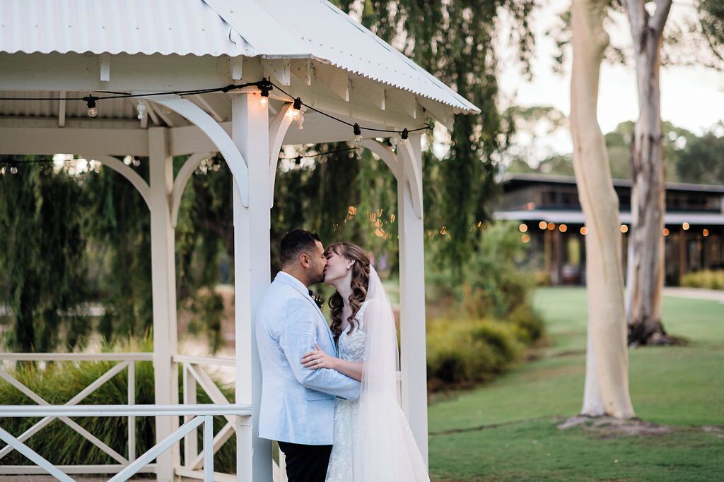 A gazebo with a white structure and string lights.