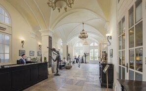 A spacious lobby with high ceilings, a reception desk, and a chandelier. - Palace Gate Hotel & Residence by EHM (Phnom Penh)