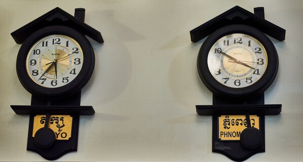 Deux horloges murales, dotées de boîtiers noirs et de cadrans blancs, et chacune est agrémentée d’une petite plaque placée en dessous.