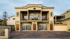 A two-story building with a symmetrical facade, large windows, and a central entrance.