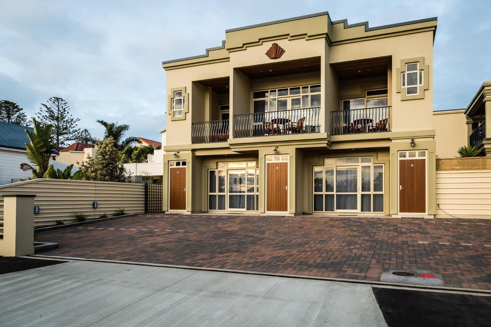 A two-story building with a flat roof, large windows, and a balcony on the upper floor.