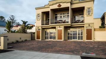 A two-story building with a flat roof, large windows, and a balcony on the upper floor.
