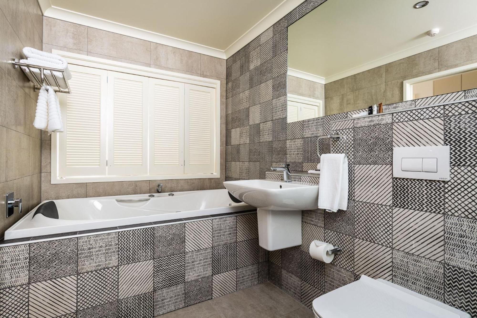 A modern bathroom with a bathtub, sink, and toilet.