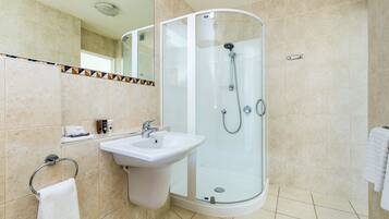 A modern bathroom with a glass-enclosed shower, a sink, and a mirror.