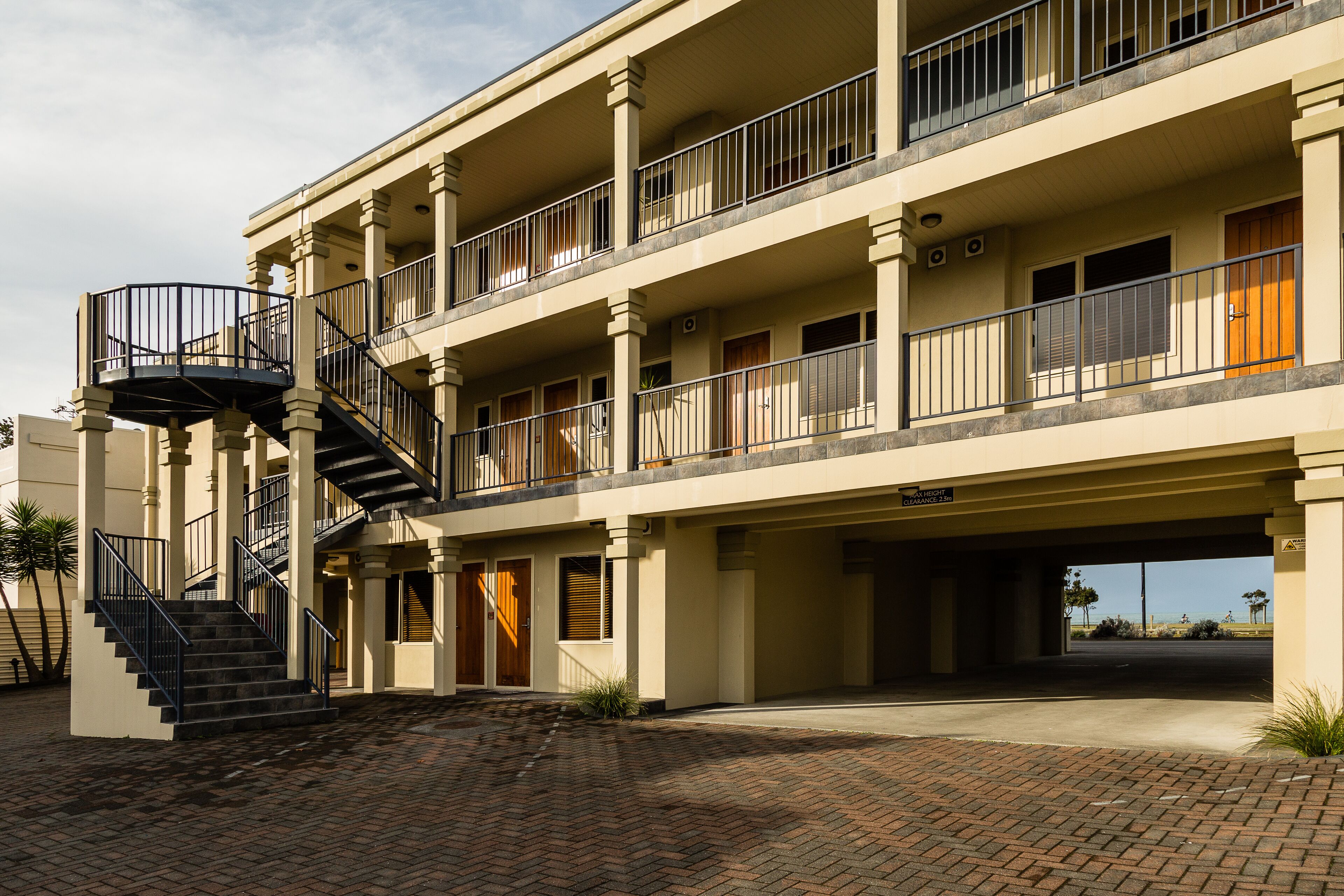 A multi-story building with a central staircase, balconies, and a covered entrance.