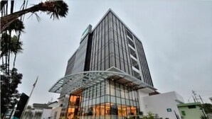 A modern building with a glass facade and a curved entrance.