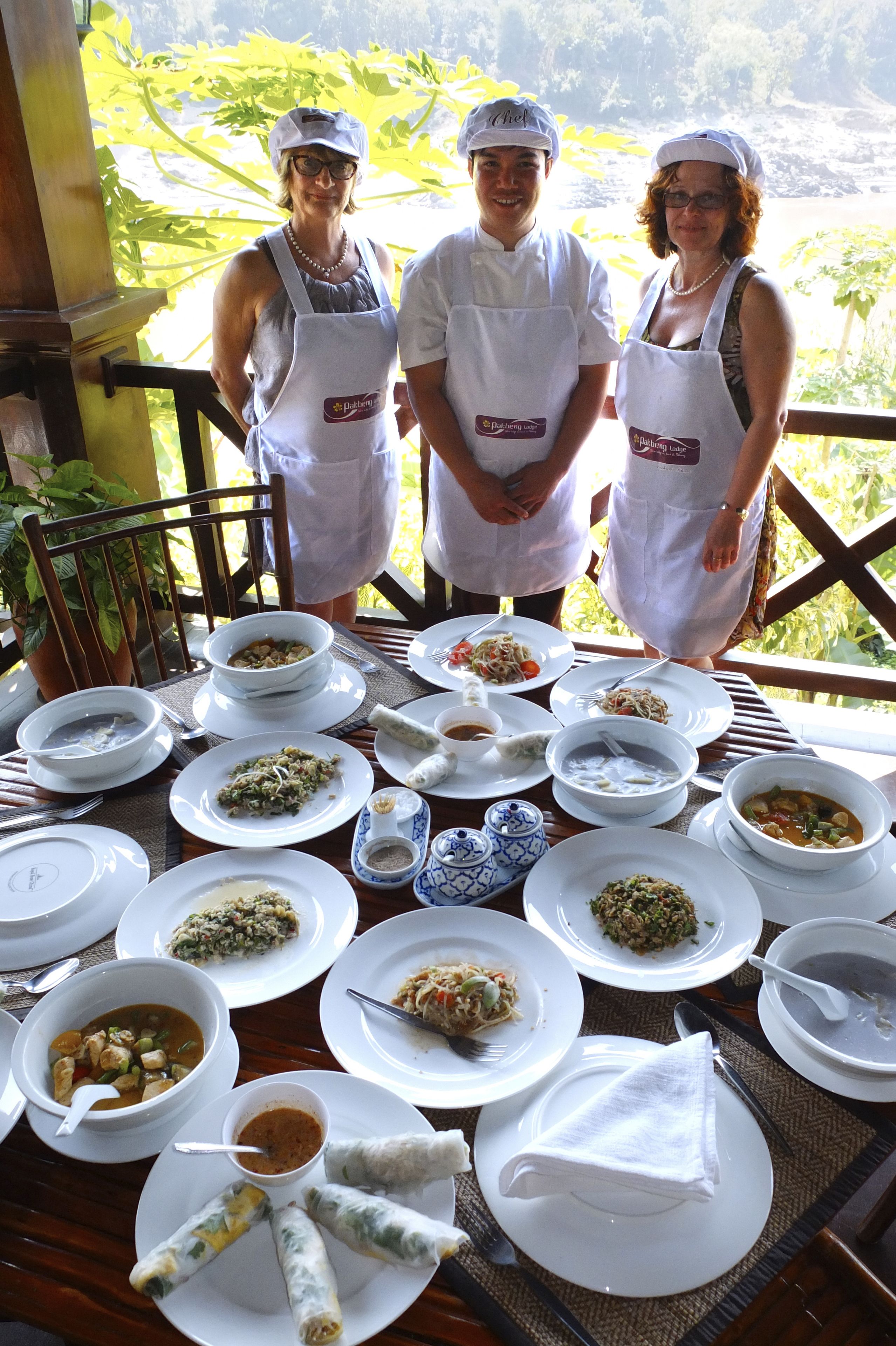 A table set with various dishes and a view of a lush landscape.