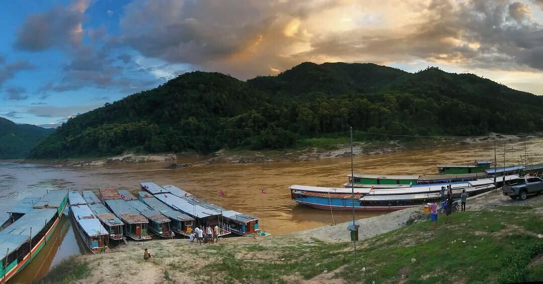 Um cais à beira do rio com barcos e um pequeno edifício.