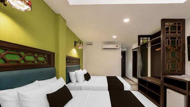 A hotel room with two beds, a wardrobe, and a built-in desk. - OYO Swiss Hotel Heritage Boutique Melaka (Malacca City)