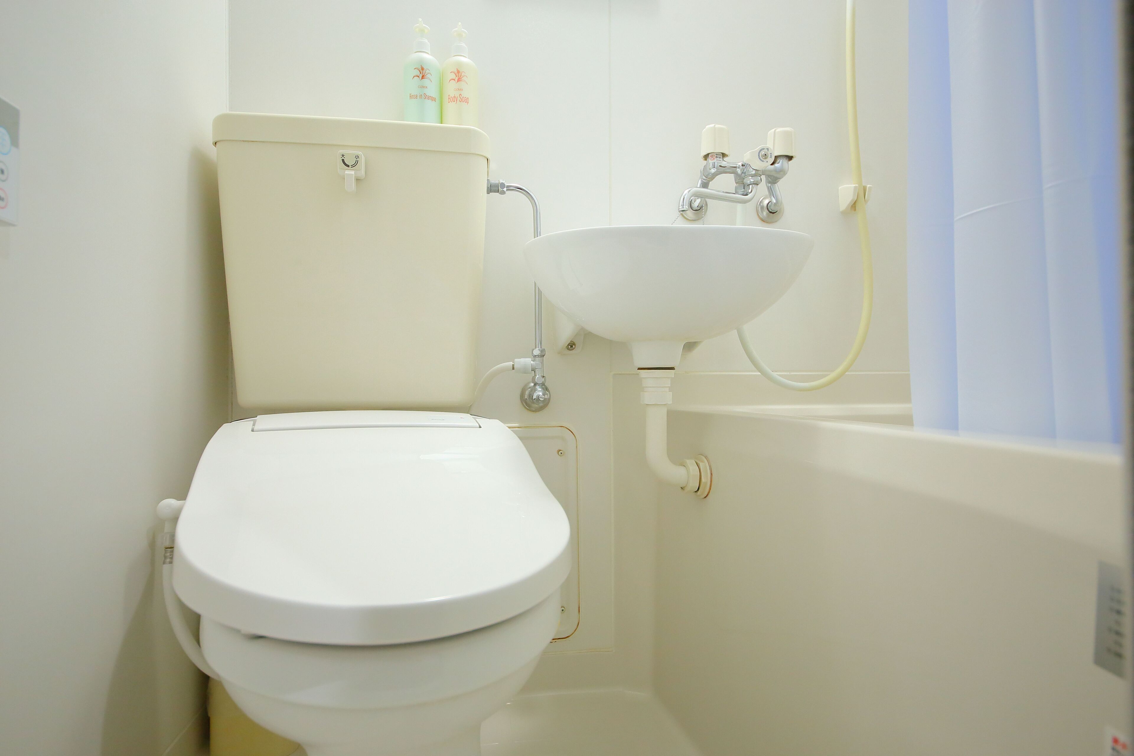 A bathroom with a toilet, sink, and shower.