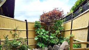 A small garden with a pond, bamboo fence, and potted plants. - Sansou Tanaka (Yufu)