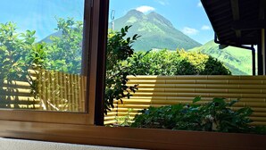 A window with a view of a mountain and greenery. - Sansou Tanaka (Yufu)