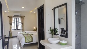 A hotel room with two beds, a large mirror, a white sink, and a green bowl. - Starfruit Villa Hoi An (Da Nang)