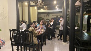A dining area with wooden tables and chairs, hanging lights, and a tiled floor. - Starfruit Villa Hoi An (Da Nang)