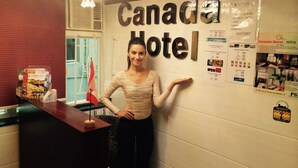 A reception desk at the Canada Hotel with a sign displaying the hotel's name.