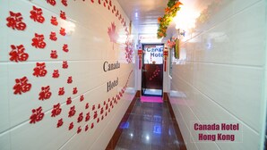 A hallway with red Chinese characters and a Canada Hotel sign.