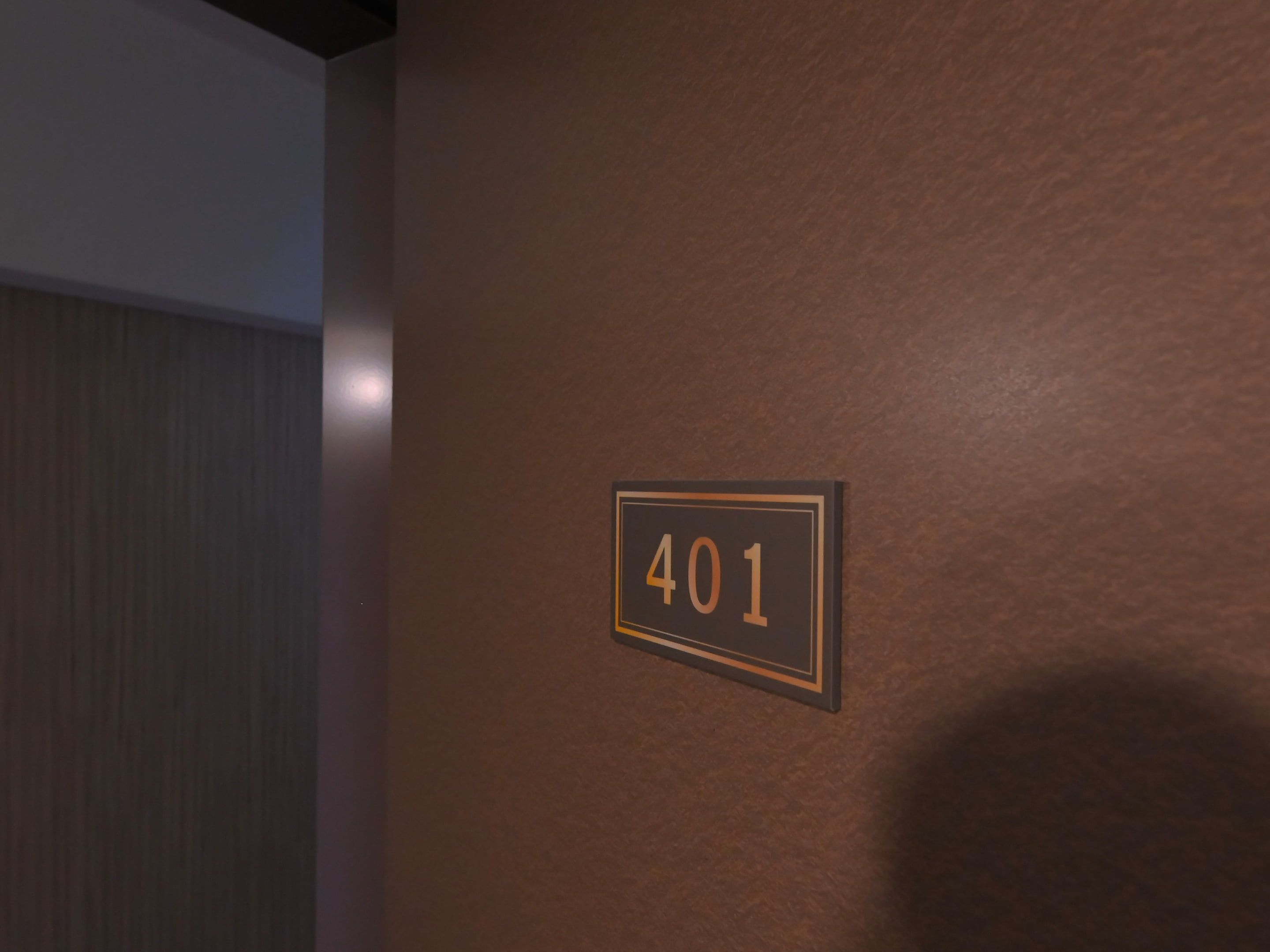 A wall with a number sign indicating room 401.