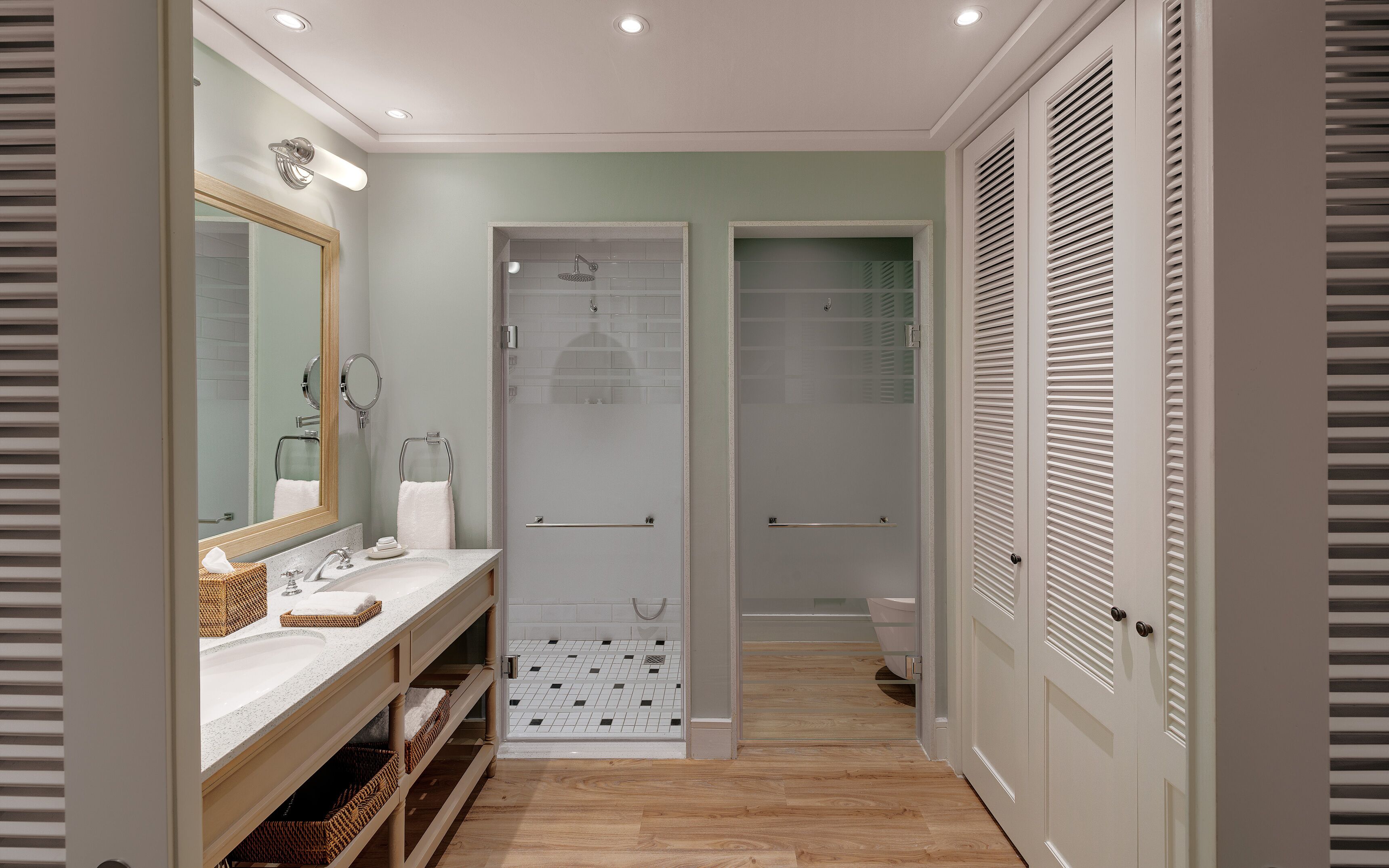 A modern bathroom with a vanity, a shower, and a toilet.