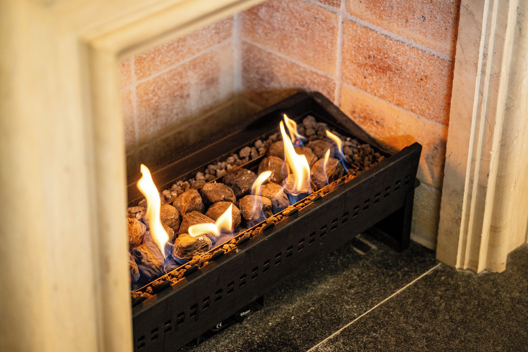 A fireplace with burning logs and flames.
