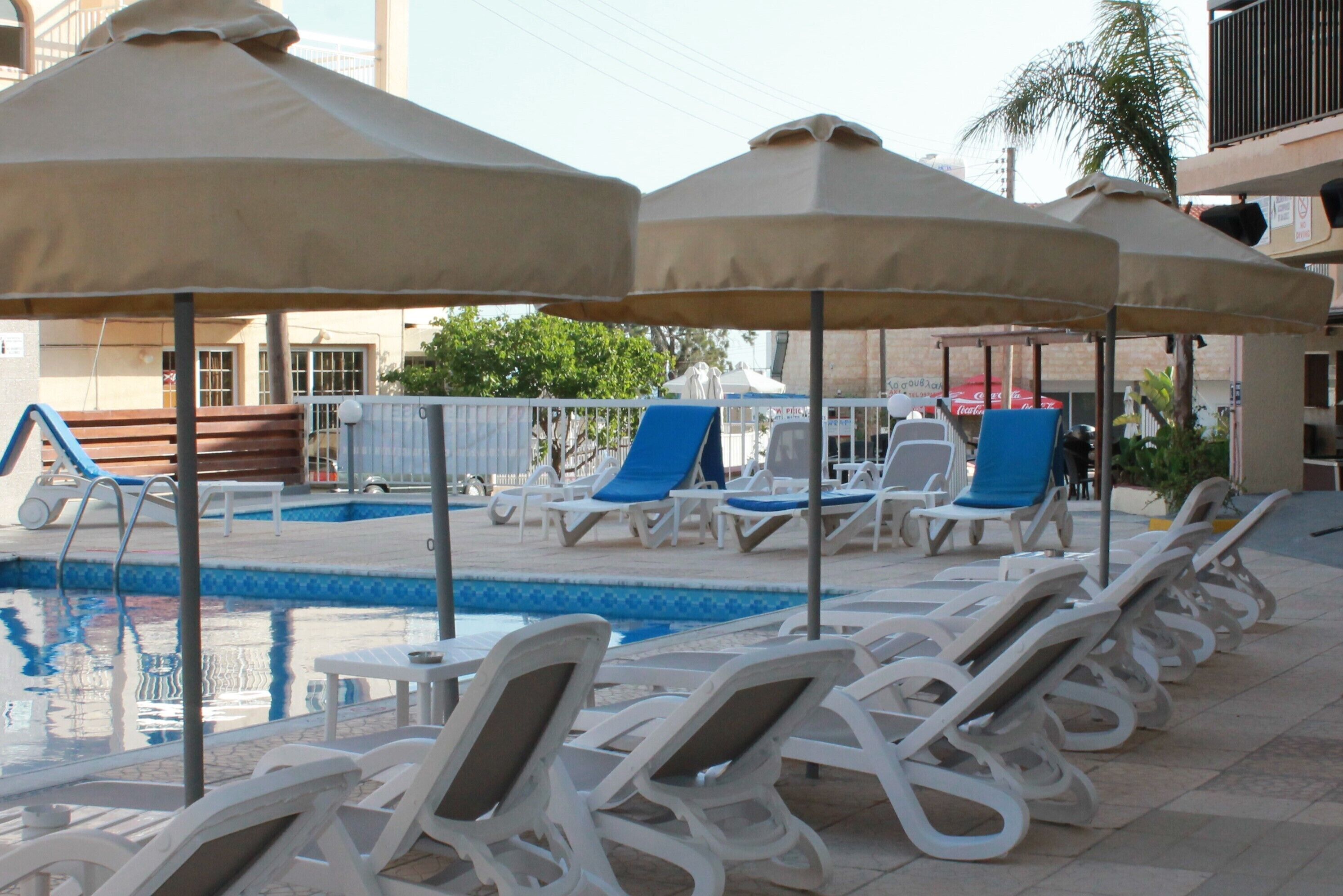A poolside area with lounge chairs and umbrellas.