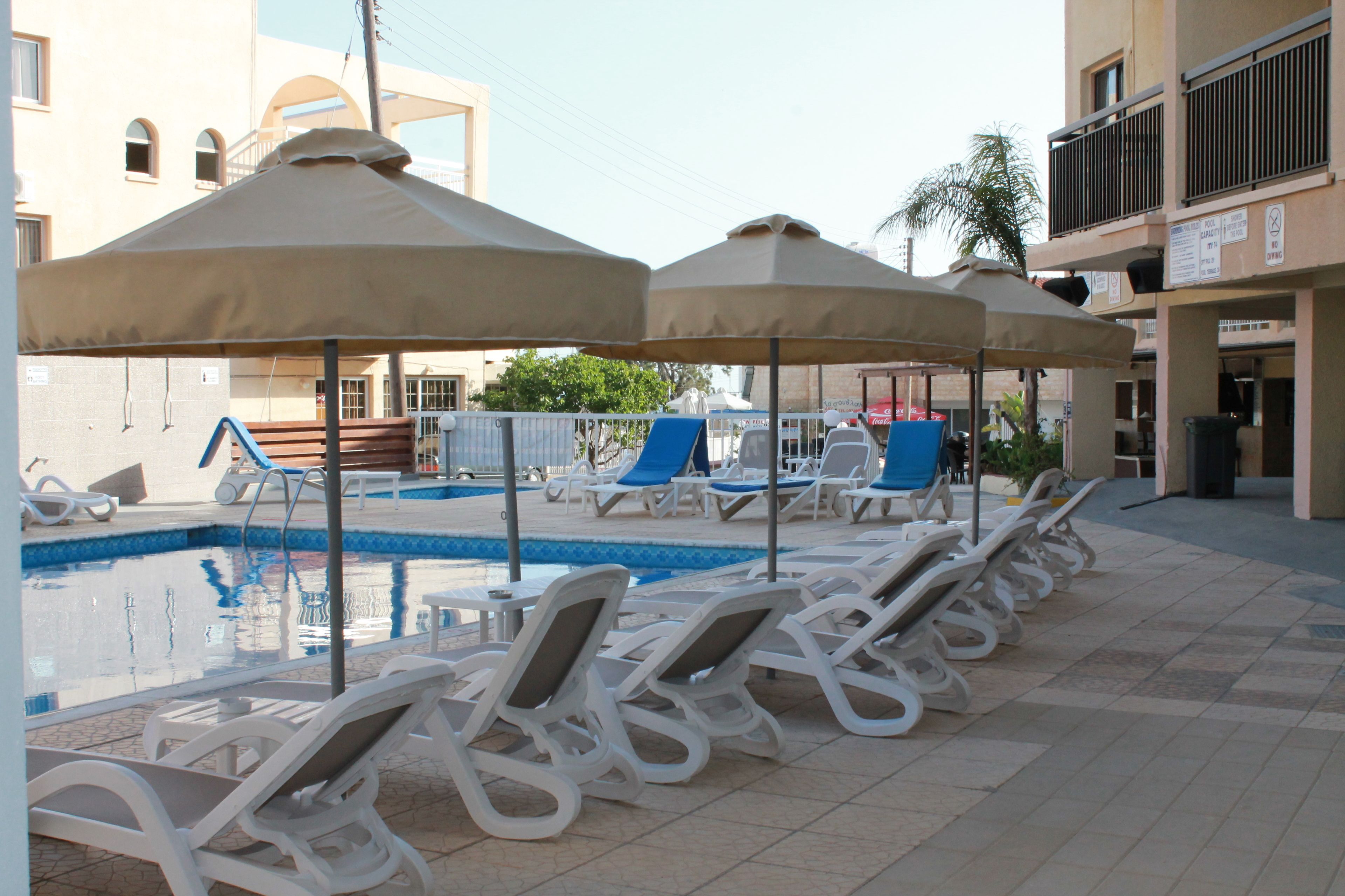 A poolside area with lounge chairs and umbrellas.