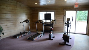 A gym with treadmills, an elliptical, and a stationary bike. - Paddle Wheel Inn (Oregon)
