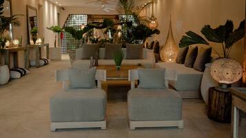 A modern living room with a sofa set, a coffee table, and decorative plants.