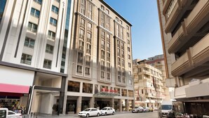 Un hôtel à plusieurs étages, doté d’une façade moderne, de grandes fenêtres et d’une entrée au niveau du sol avec une enseigne bien visible.