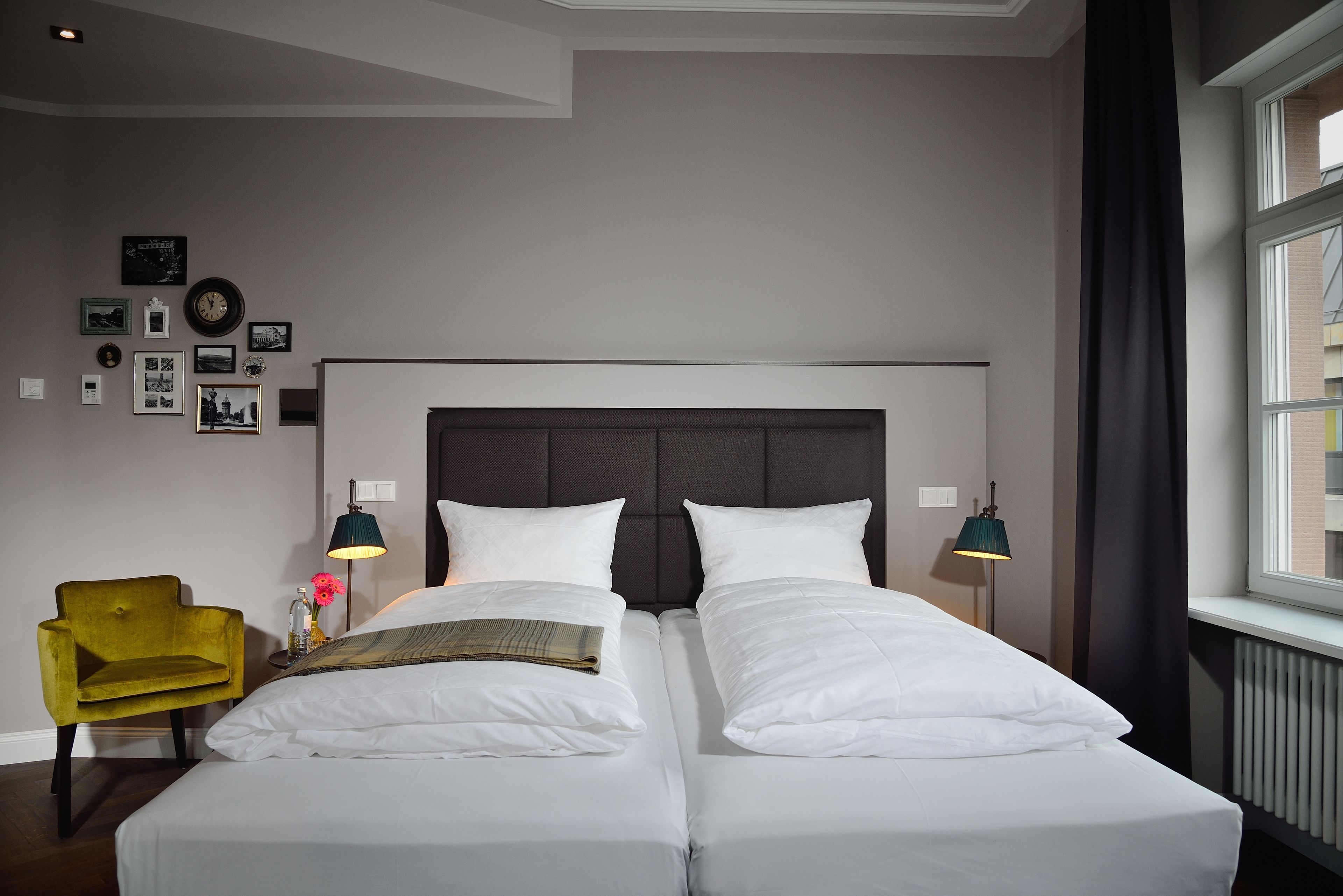 A double bed with white linens, a dark headboard, and two bedside lamps.