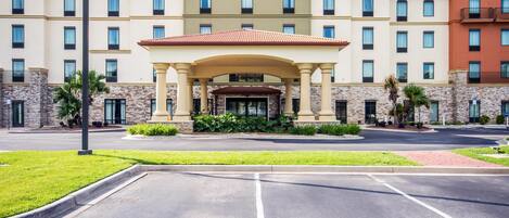 Ein Hotel mit zentralem Eingang, mehreren Stockwerken und einer Steinfassade.