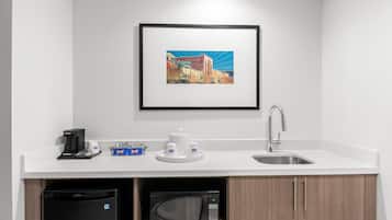 A modern kitchen with a coffee machine, microwave, and sink.