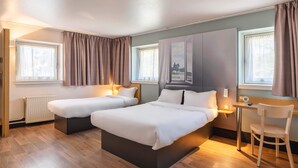 A hotel room with two beds, a desk, and a chair. - B&B HOTEL Lyon Centre Monplaisir (Lyon)