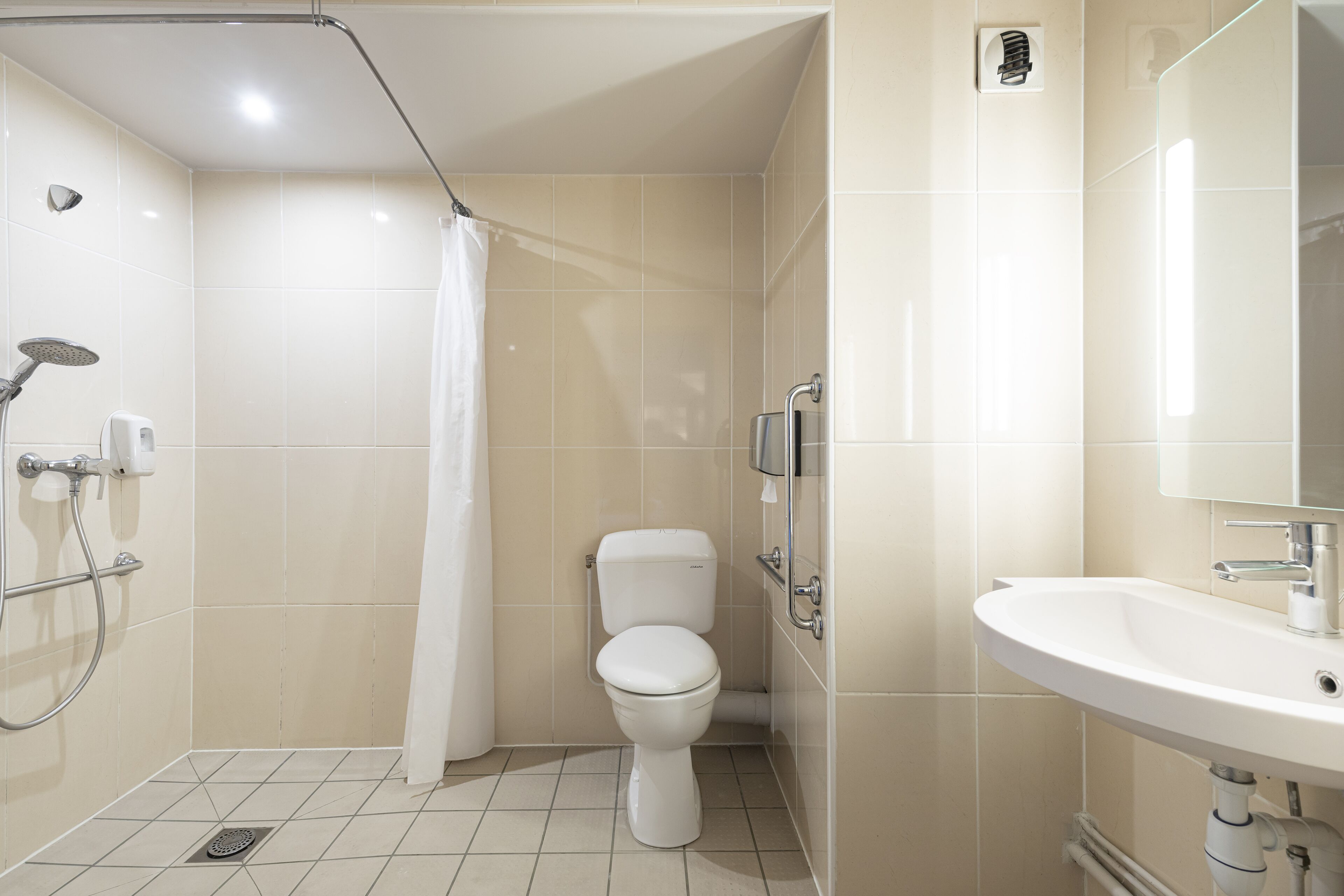 Un baño con ducha, inodoro y lavabo.