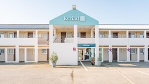 A hotel with a reception area, multiple balconies, and a parking lot. - Kyriad ECO - Lorient Lanester (Lanester)