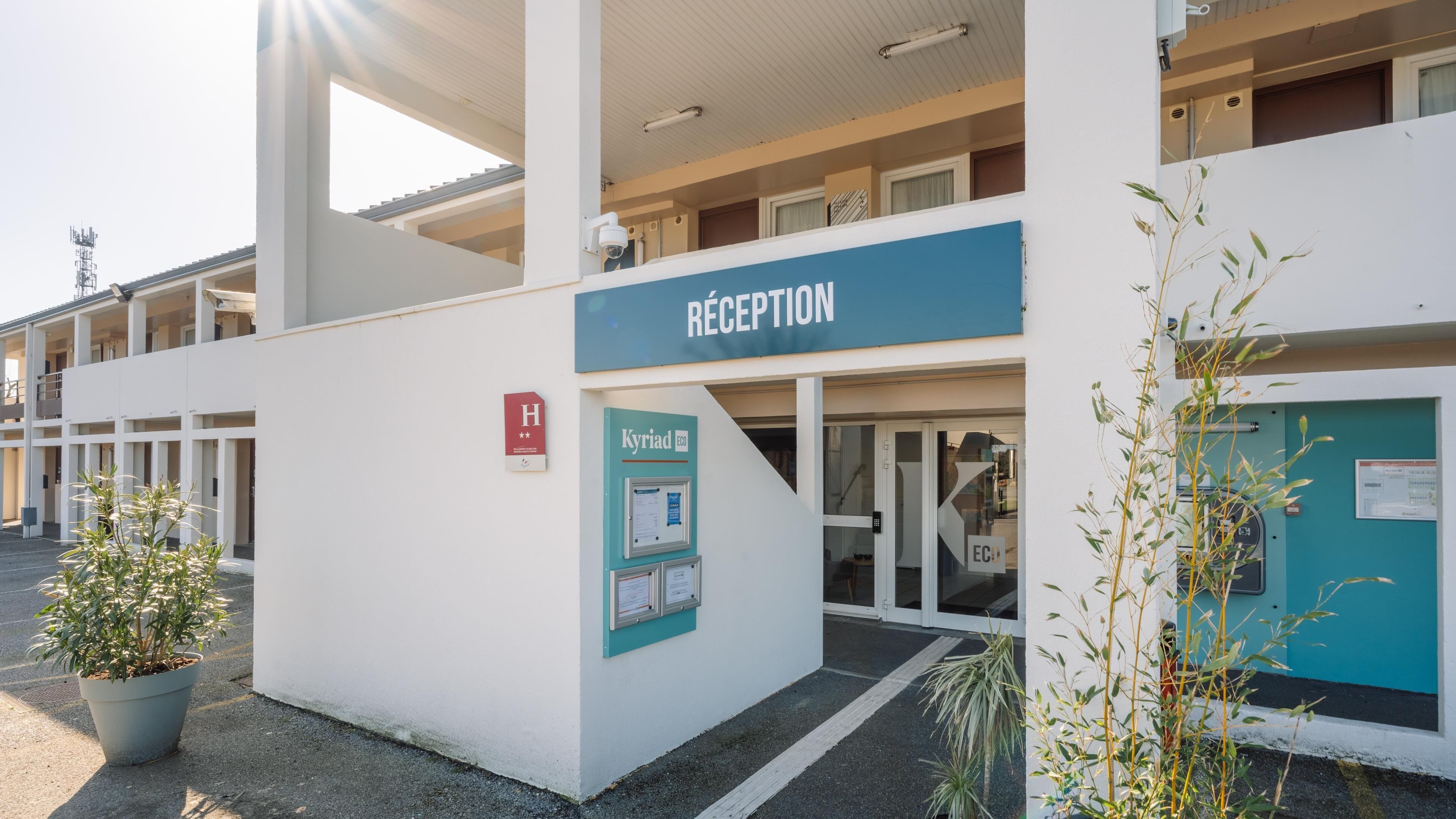 A hotel reception area with a sign reading 'RECEPTION,' a wheelchair accessibility sign, and a notice board.