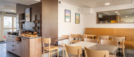 A restaurant interior with a counter, chairs, and tables.