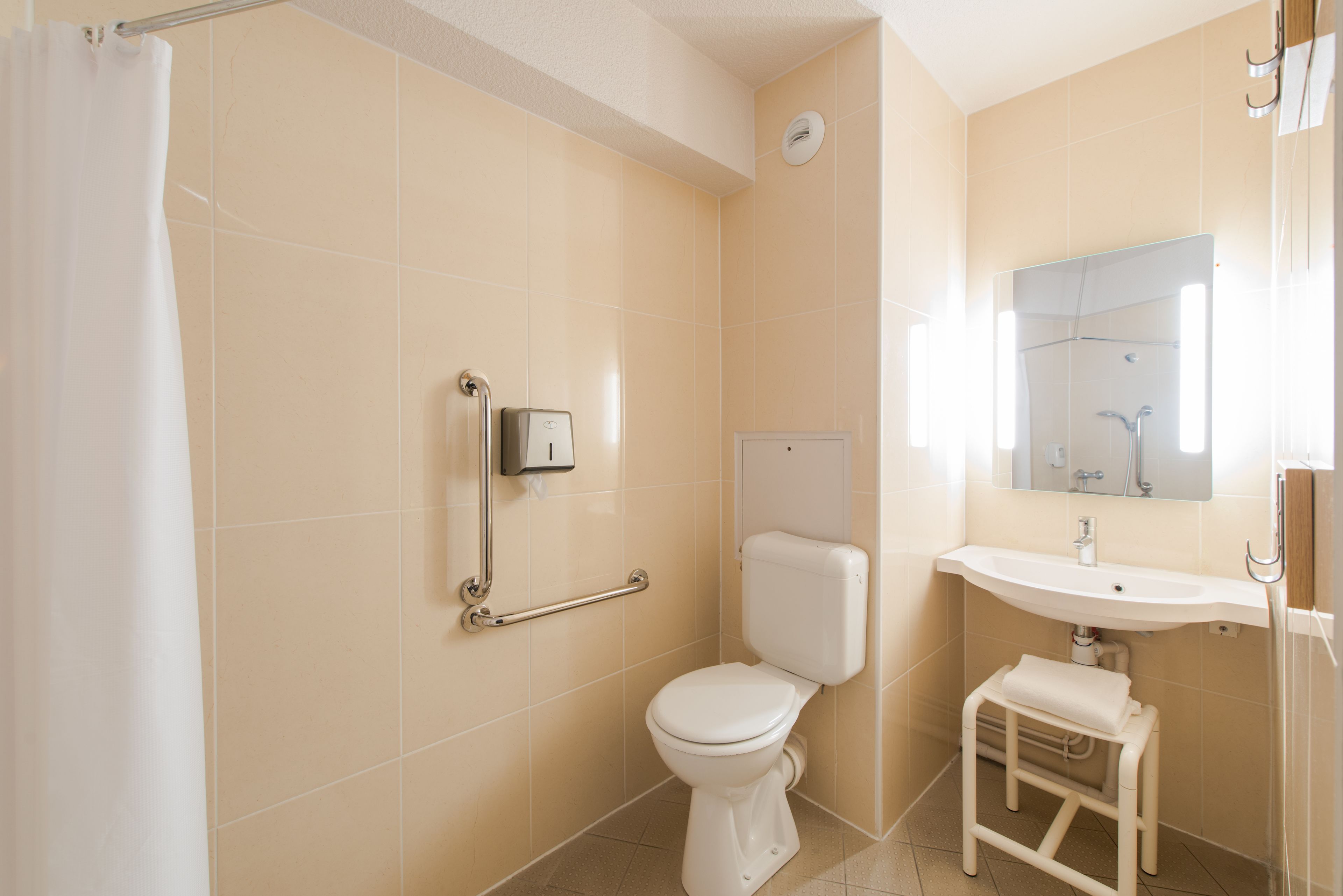 A bathroom with a toilet, sink, and shower.