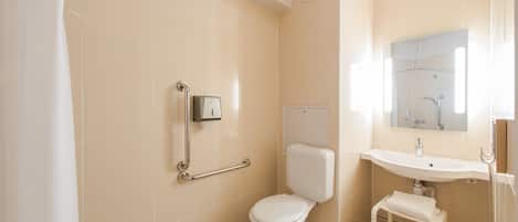 Un baño con inodoro, lavamanos y ducha.
