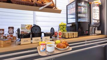 Un buffet de petit-déjeuner proposant une variété d’aliments, notamment des viennoiseries, des fruits et des boissons.