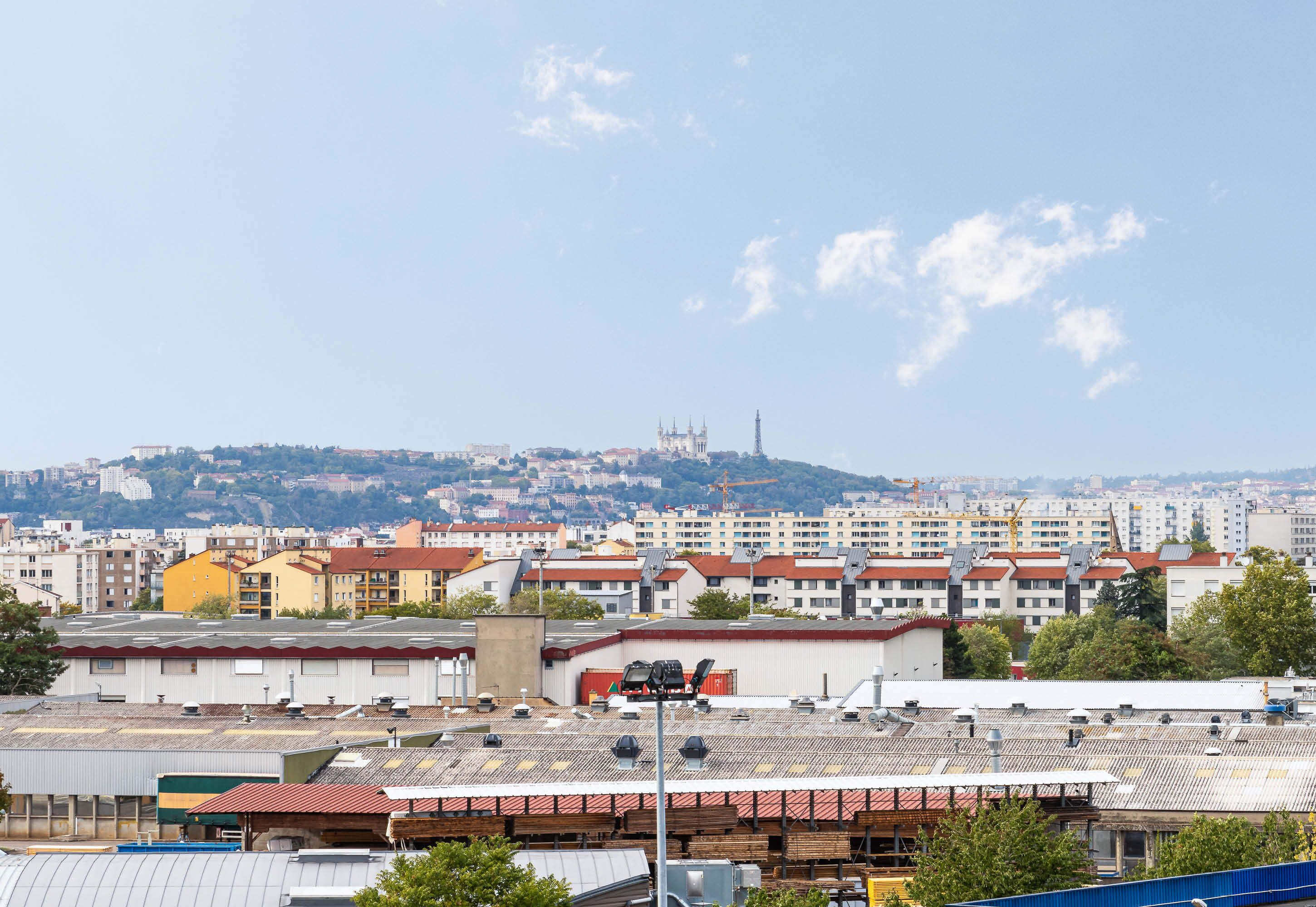 A cityscape with a prominent cathedral in the distance, surrounded by residential buildings and industrial structures.