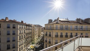 A street view with buildings on either side, a clear sky, and the sun shining. - B&B HOTEL Marseille Centre La Joliette (Marseille)
