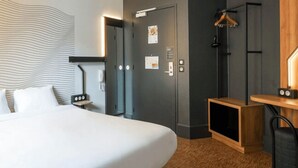 A hotel room with a large bed, a desk with a chair, a wardrobe, and a shower area. - B&B HOTEL Marseille Centre La Joliette (Marseille)