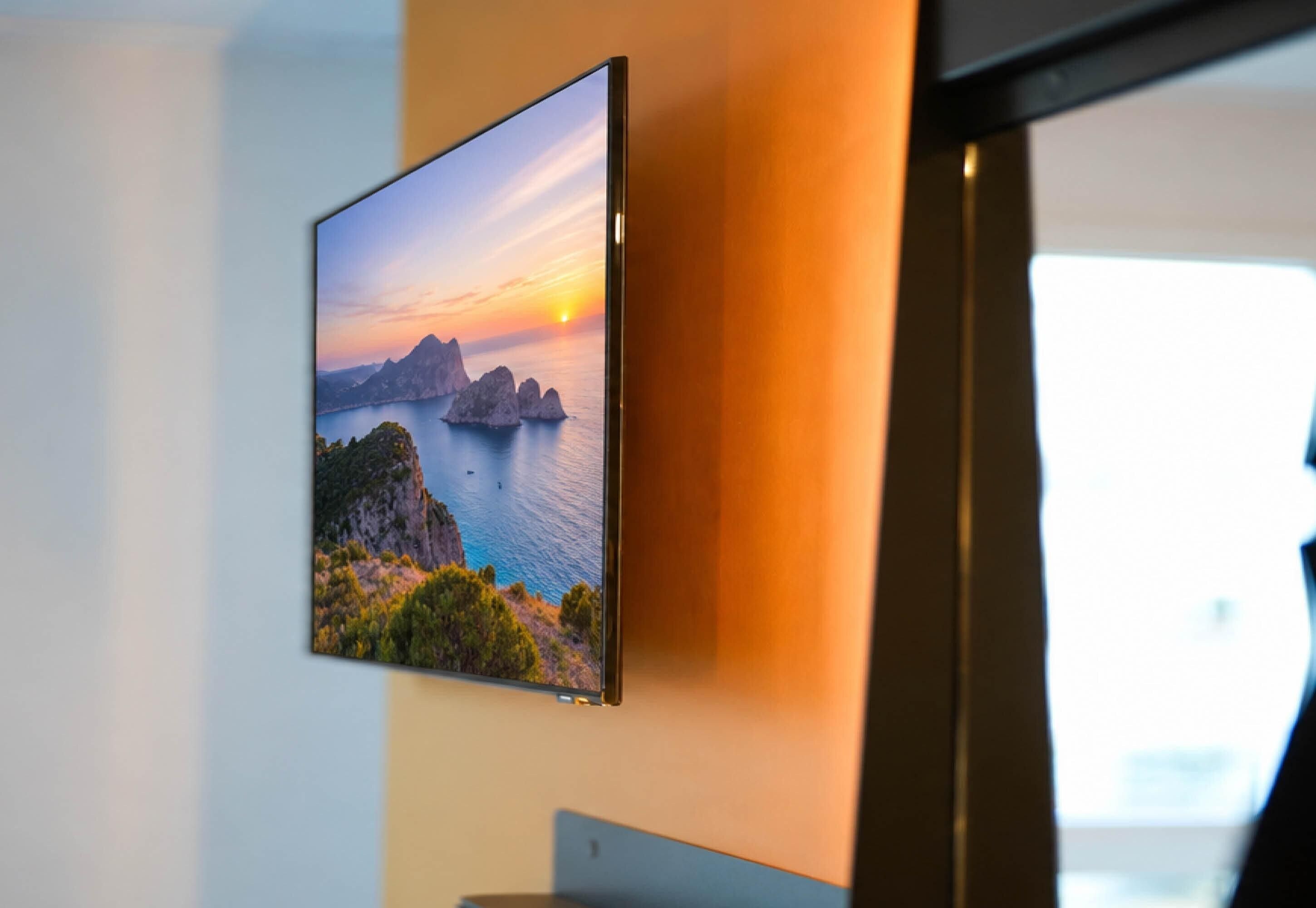 Un televisor de pantalla plana montado en la pared que muestra un paisaje pintoresco.
