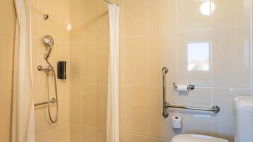 A bathroom with a shower, toilet, and grab bars.