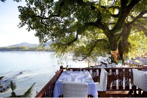 Mesa lista para comer con vistas al mar y a las montañas.