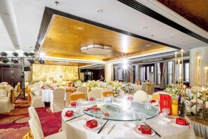 A banquet hall with round tables, chairs, and floral arrangements. - Yuntian Garden Hotel (Kunming)
